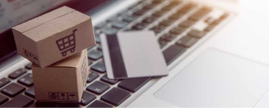 Caixinhas de compra e cartão de crédito em cima de teclado de notebook após compras na plataforma marketplace B2B.