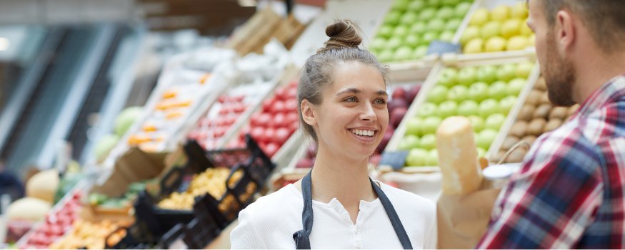 Vendedora sorrindo para cliente após quebrar objeções em vendas.