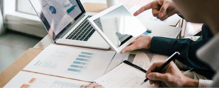 Homens fazendo anotações e verificando dados de planilhas para empréstimo para empresa.