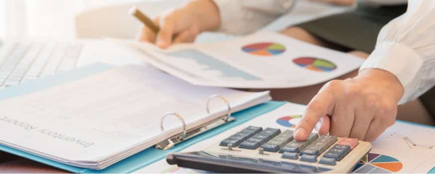 Uma pessoa analisando um gráfico e diversos dados conforme calcula o exemplo de fluxo de caixa.