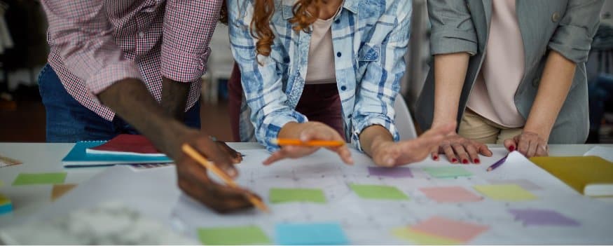 Três pessoas analisando dados e levantando Scrum o que é para determinar a gestão de resultado a empresa.